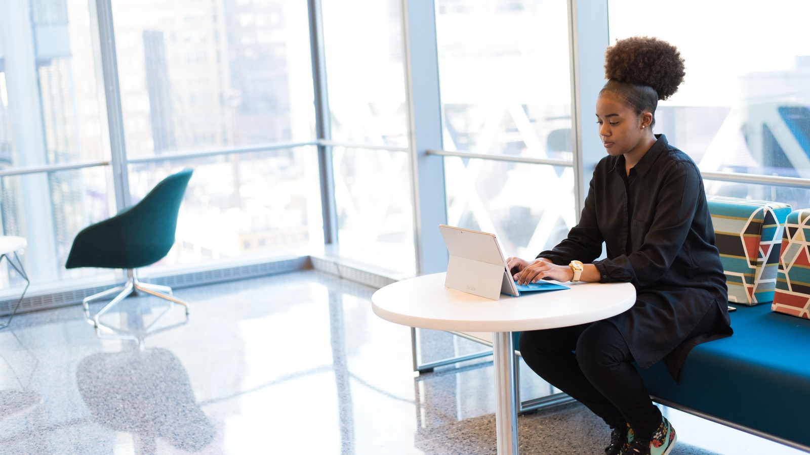 A software engineer and quality assurance specialist sitting together at a clean wooden desk, reviewing a clean video bug recording on a wide monitor in a brightly lit modern office.